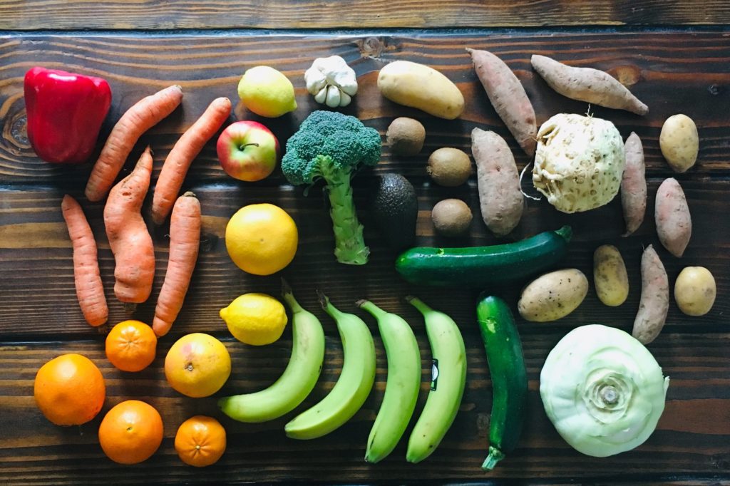 misfit fruits and vegetables on table in rainbow color order