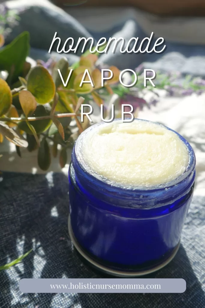 diy vapor rub sitting in front of eucalyptus leaves and purple flowers