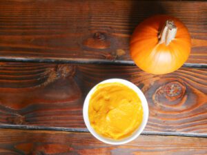 instant pot pumpkin puree in bowl next to sugar pumpkin