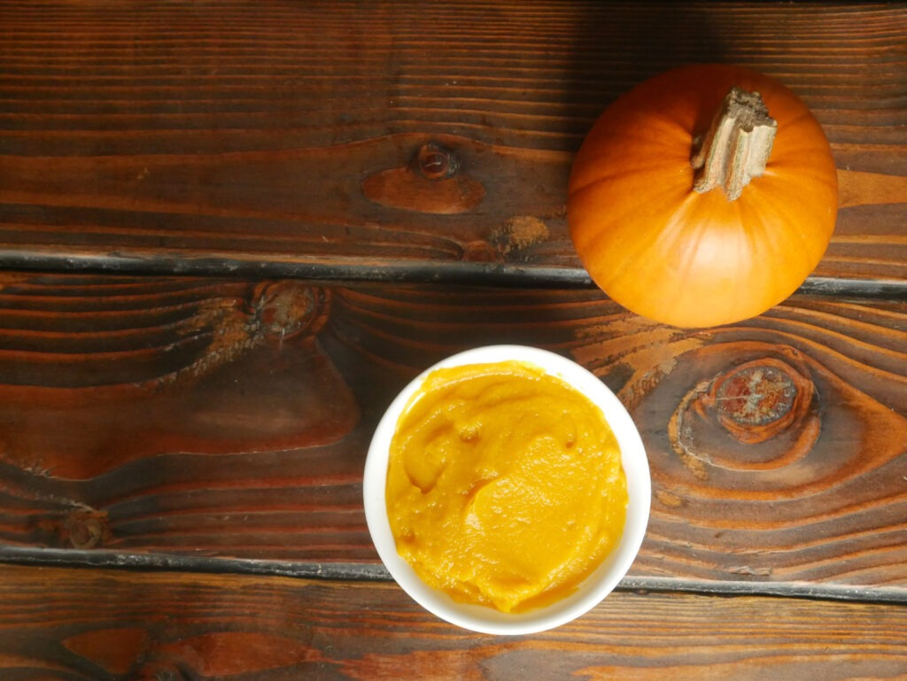 sugar pumpkin next to bowl of homemade pumpkin puree