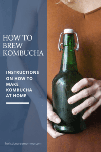 home brew kombucha in green bottle; green bottle kombucha being held