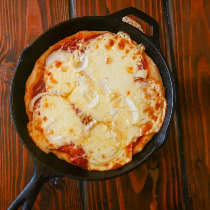 baked pizza made with sourdough pizza dough and topped with pizza sauce and cheese