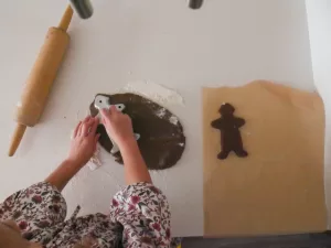 girl making sourdough gingerbread men cookies