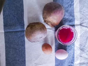 naturally dyed easter eggs sitting next to 2 beets.