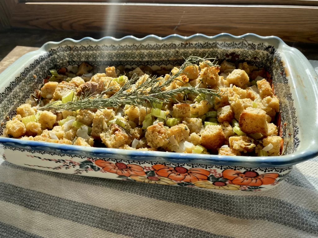 sourdough stuffing in a polish pottery casserole dish with dried rosemary on top