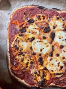 cooked, sourdough pizza on parchment paper