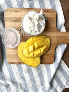 mango with whipped mango body butter in a glass jar