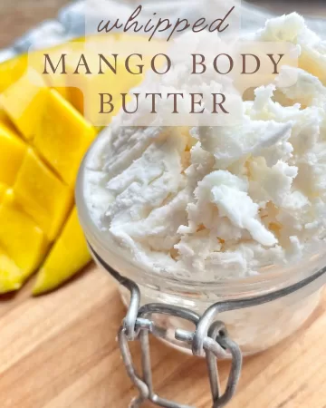 mango next to homemade whipped mango body butter in a glass jar