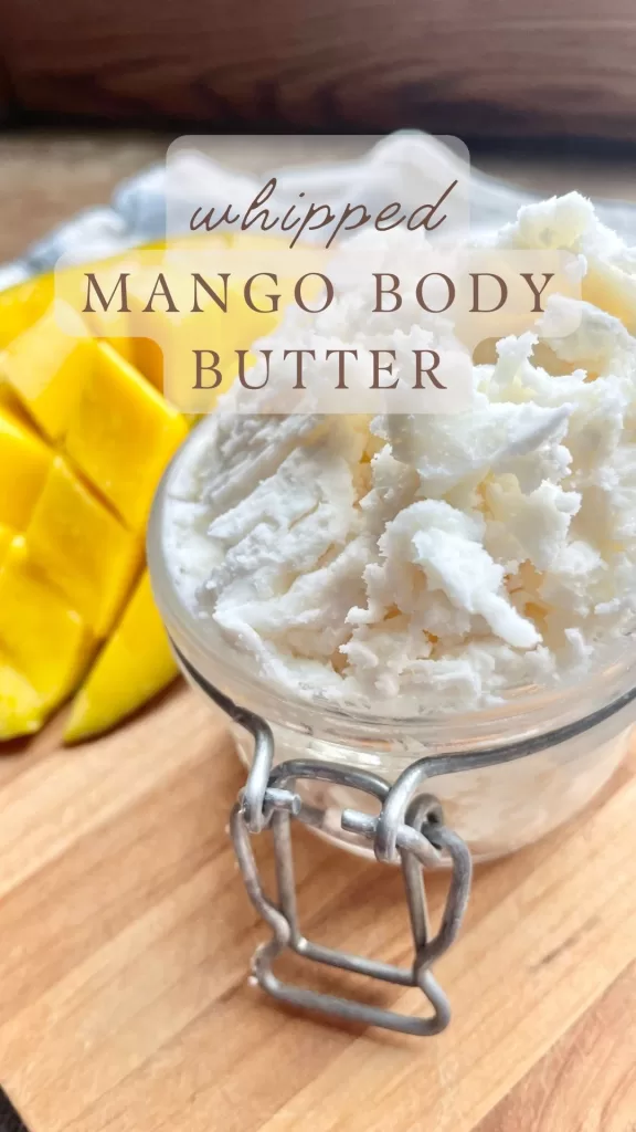 mango next to homemade whipped mango body butter in a glass jar