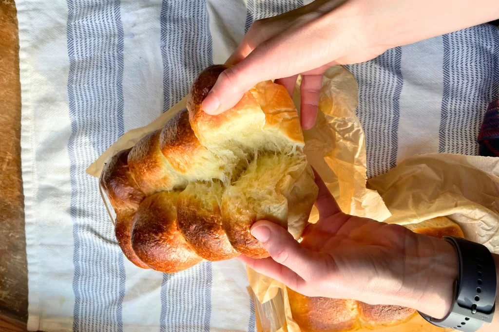 brioche buns being split apart by hands