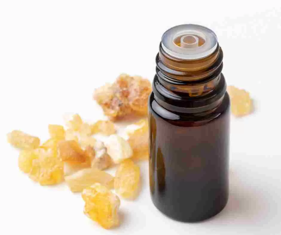 frankincense resin next to essential oil bottle