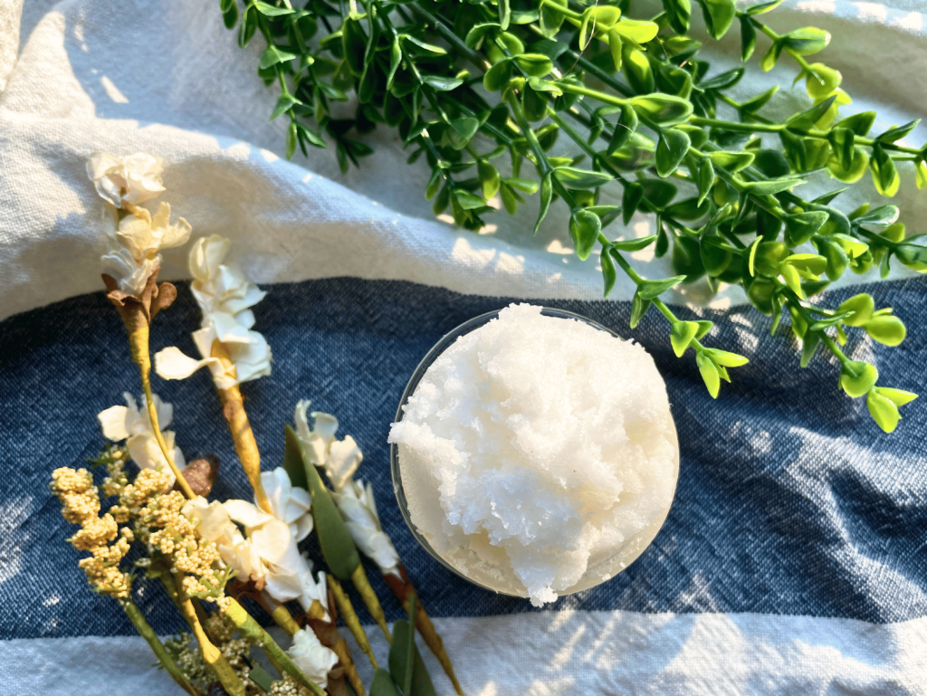 whipped sugar soap scrub sitting next to flowers and leaves