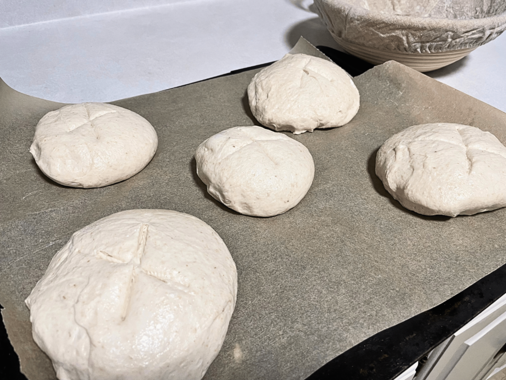 scored sourdough bread bowls on parchment paper