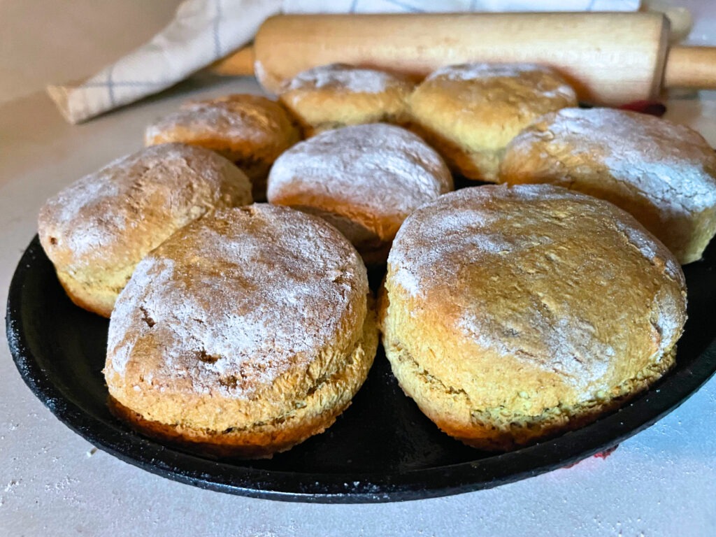 fresh milled flour biscuits sitting on a flat cast iron pan