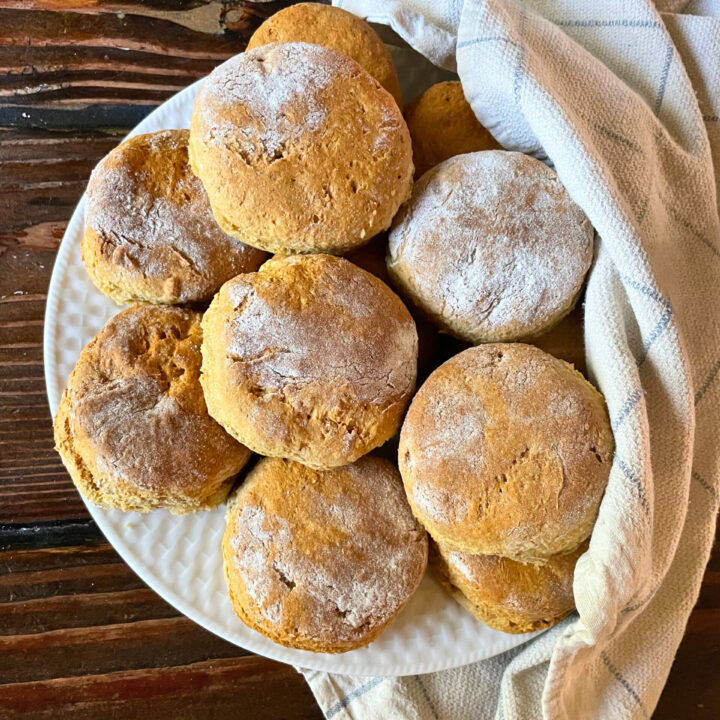 fresh milled flour biscuits on white plate with a towel