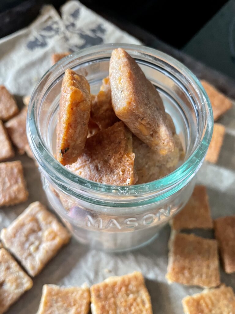 sourdough discard crackers with cheese and freshly milled flour in a glass storage jar