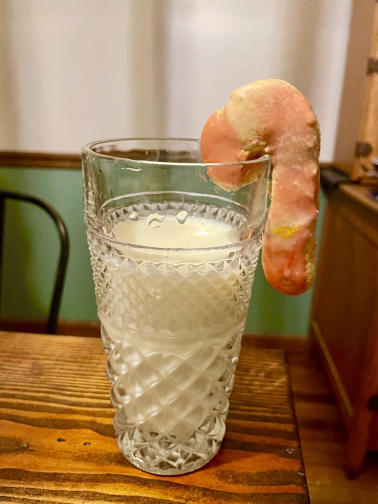 fresh milled flour candy cane sugar cookie hanging on a glass of milk