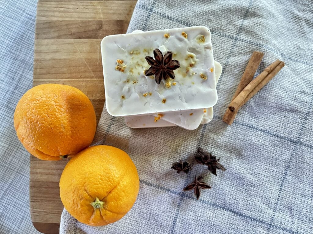 stacked fall soap surrounded by oranges, cinnamon sticks, and anise star