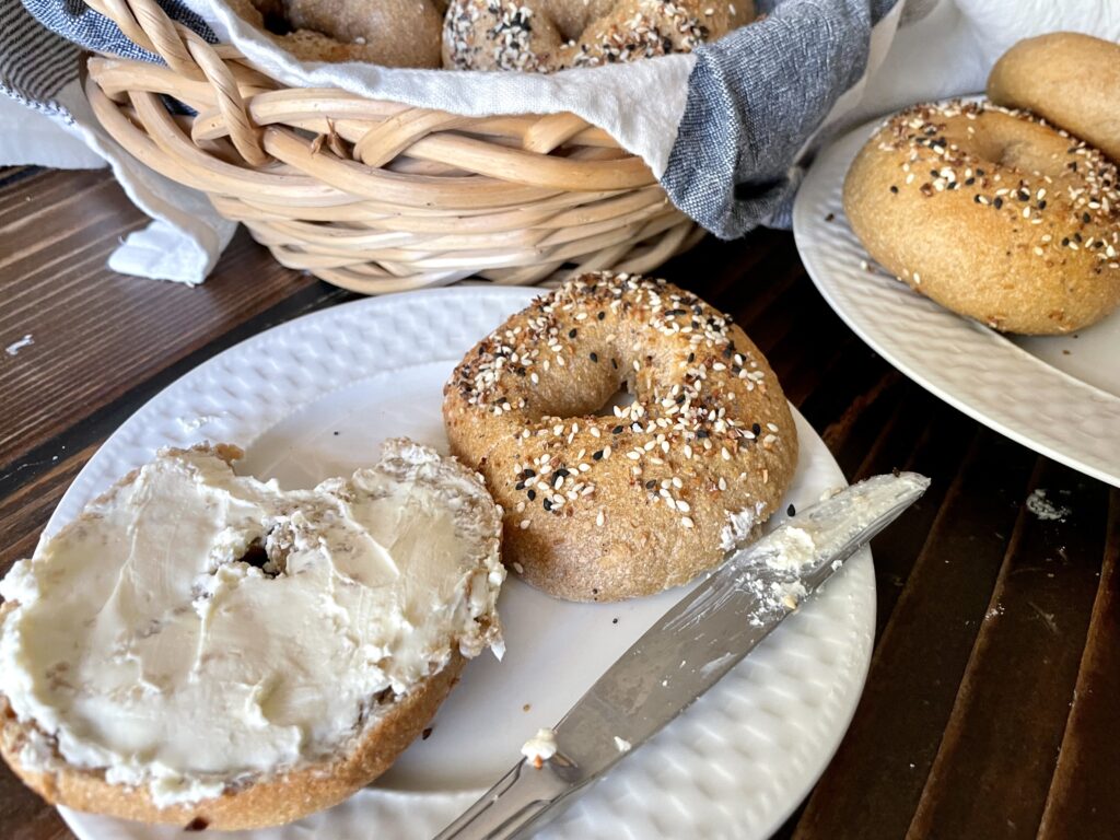 sourdough bagels with fresh milled flour with cream cheese on white plate