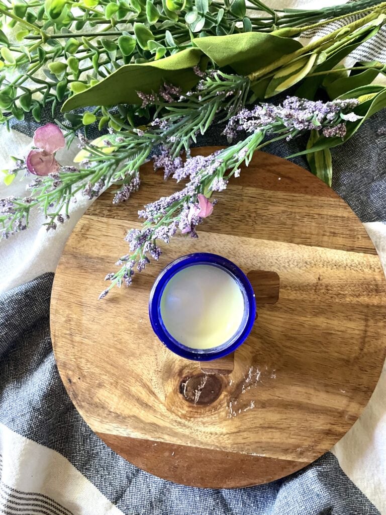 homemade deodorant cream sitting on wooden hot pad