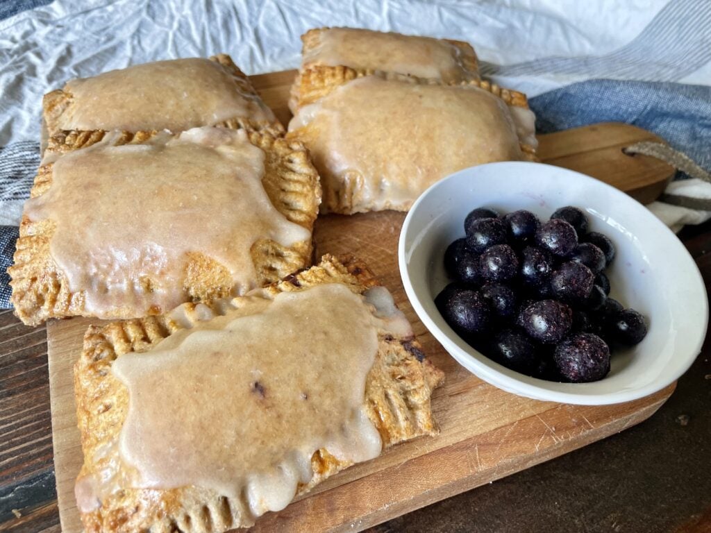 sourdough fresh milled flour pop tarts on a cutting board next to blueberries