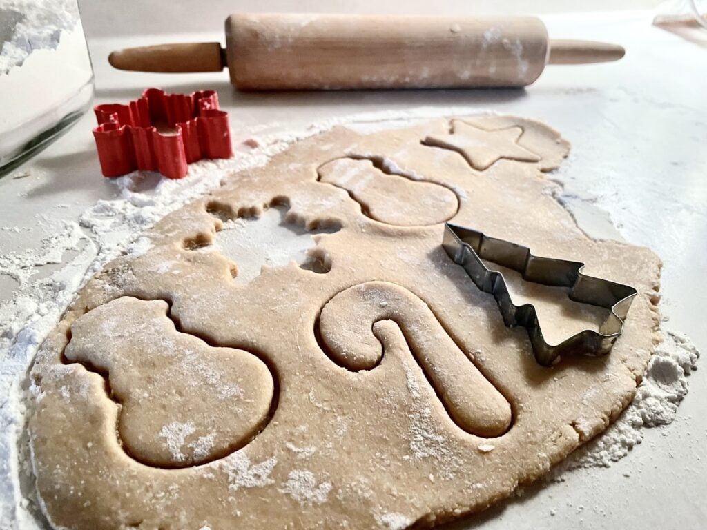 raw fresh milled flour sugar cookie dough with cookie cutters cutting out