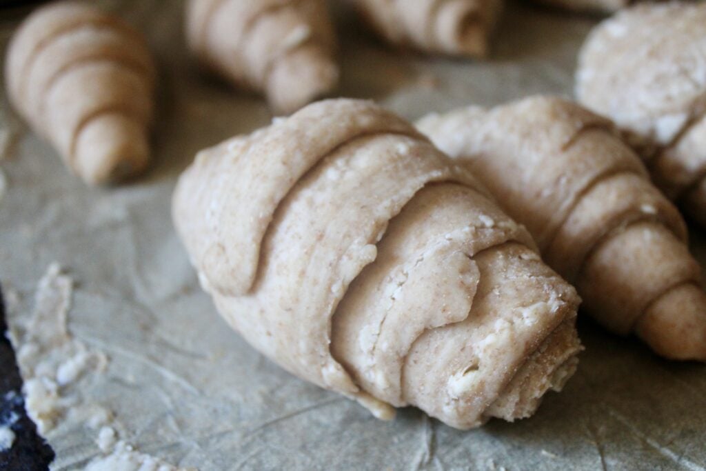 fresh milled flour sourdough croissant rolled into shape, proofing on parchment paper