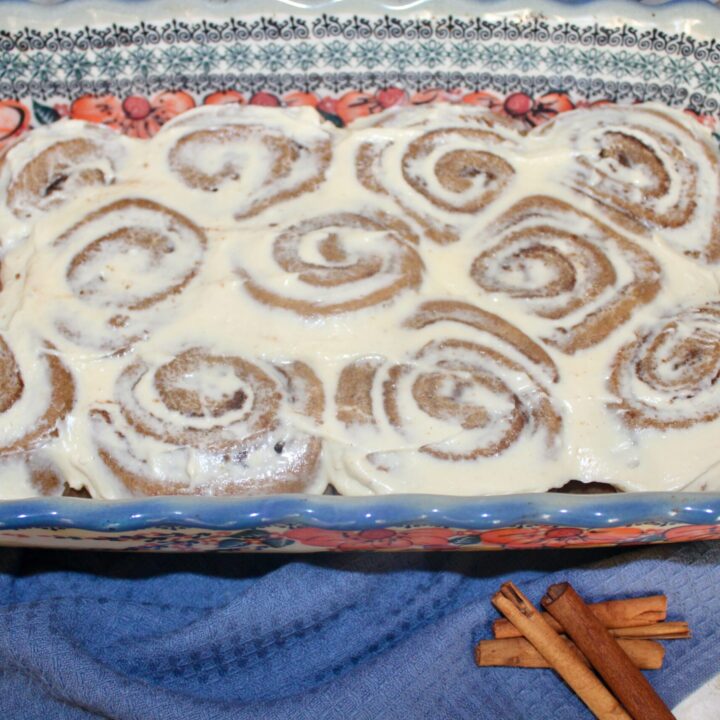 pan of fresh milled flour sourdough cinnamon rolls next to cinnamon sticks
