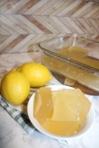 lemons behind a small bowl with cubed beef gelatin lemon jello